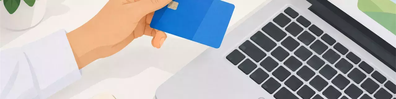 Sosteniendo la tarjeta bancaria azul junto al portátil