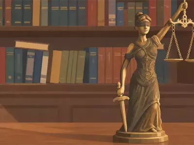Estatua de la Dama de la Justicia con balanzas y libros de leyes