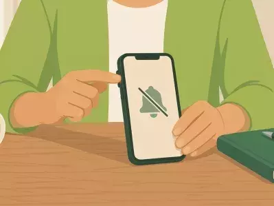 Persona silenciando teléfono junto a la libreta y el café