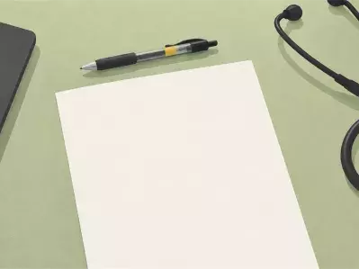 Estetoscopio con bolígrafo y papel junto al portátil