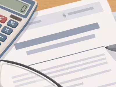 Calculadora con papeles de préstamo y gafas en el escritorio